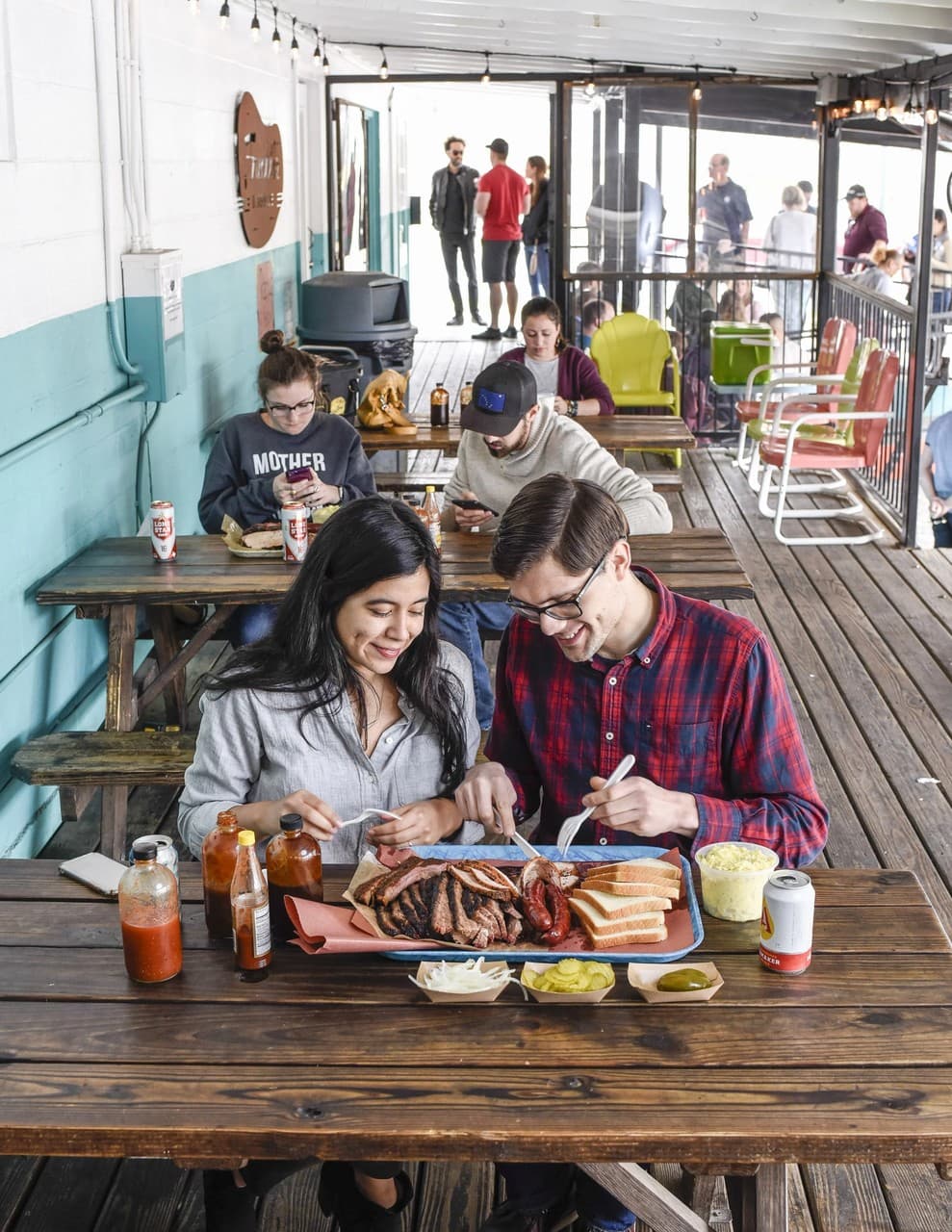 People sharing a casual barbecue meal on a rustic outdoor patio at Franklin Backyard