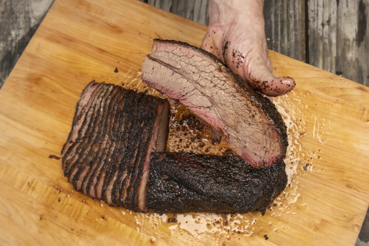 Close-up of sliced smoked beef brisket showing the perfect smoke ring